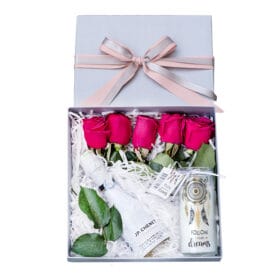 caja con vino espumoso rosas y vela decorativa