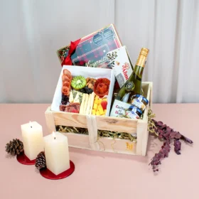 Fabulosa ancheta gourmet con vino blanco y tabla de quesos y y jamones ideal para compartir en navidad acompañada con galletas de mantequilla y mermeladas